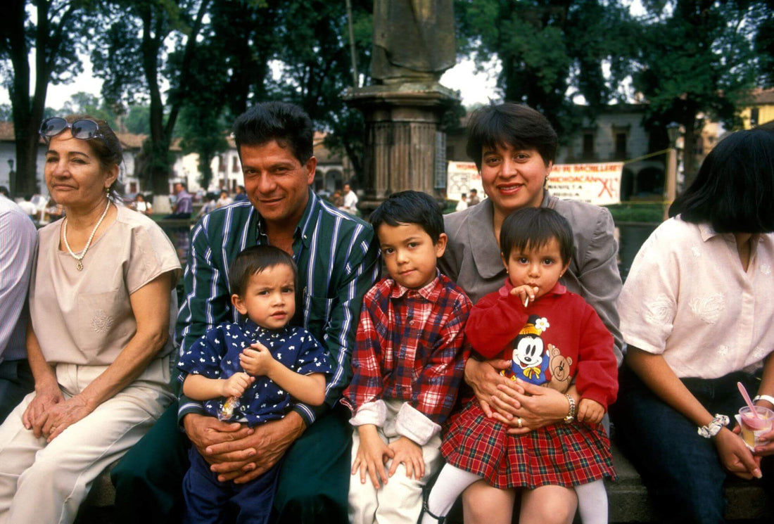 A Latino family with 3 children sit by a park in the US