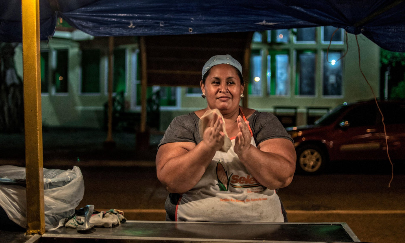 A woman making a baleada at a stall in Honduras