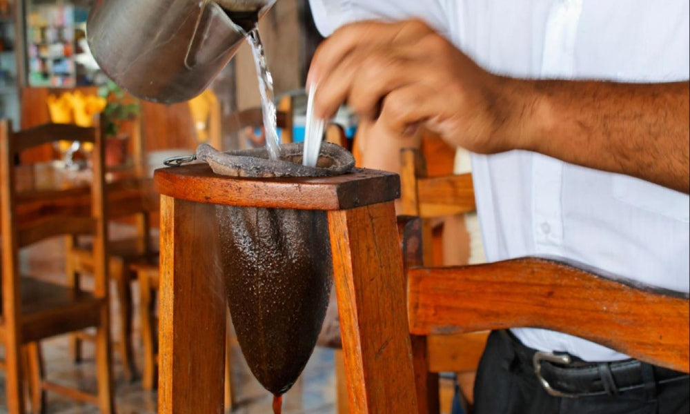 A man preparing a traditional café chorreado using a wooden frame in Costa Rica