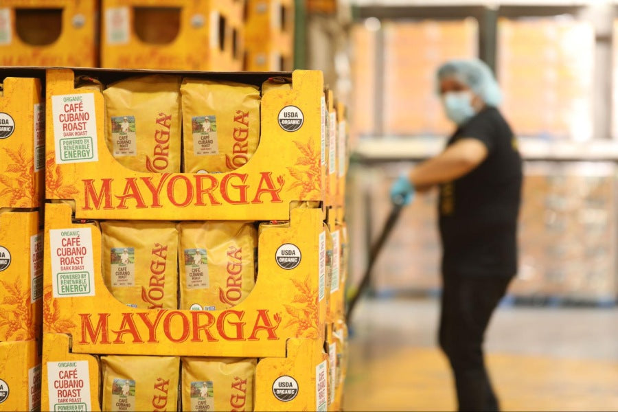 woman hygienic clothing lugging a crate of Mayorga coffee beans